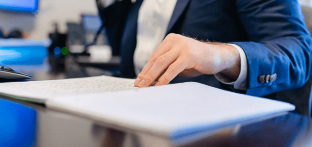 Benefits advisor reviewing funeral home employee benefits plan documents at a desk